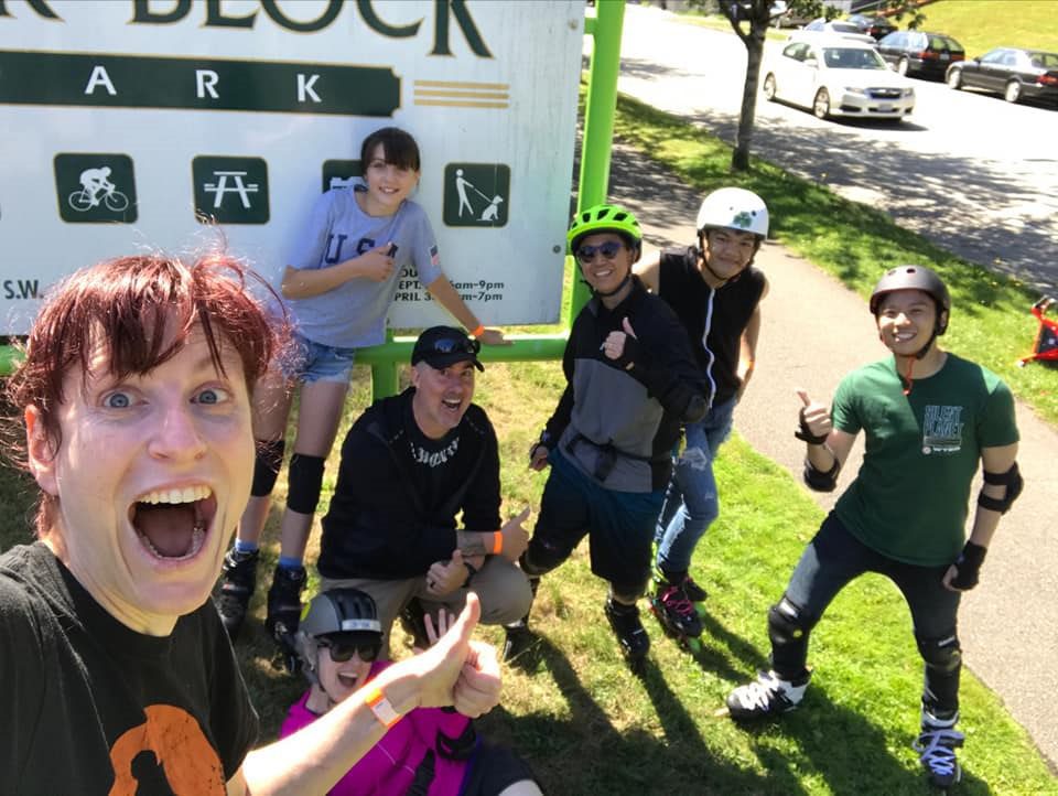 Group of people rollerblading in a park.