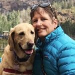 Woman smiling with a golden retriever.