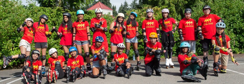 Group of kids wearing rollerblades and red shirts.