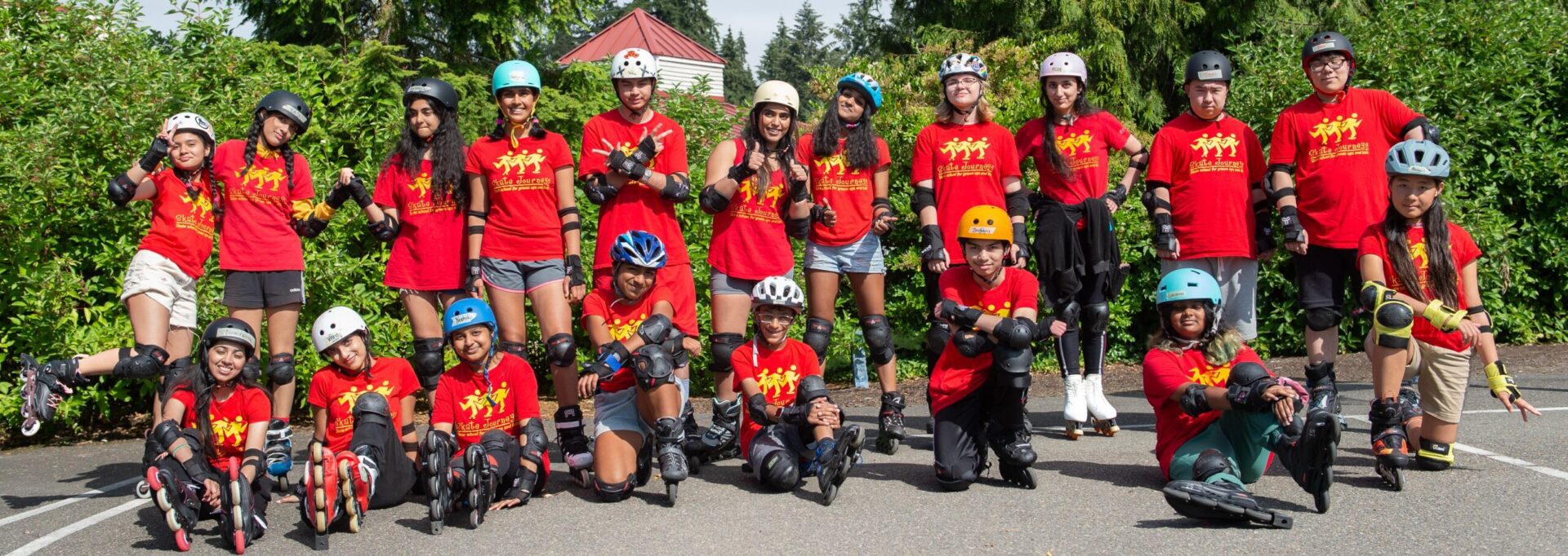 Group of kids in red shirts rollerblading.