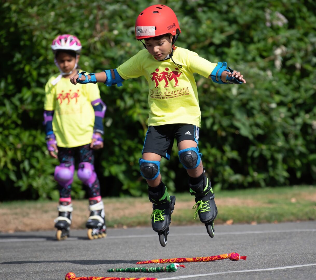 Boy in red helmet jumping on rollerblades.