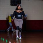 Woman in roller skates at a rink.