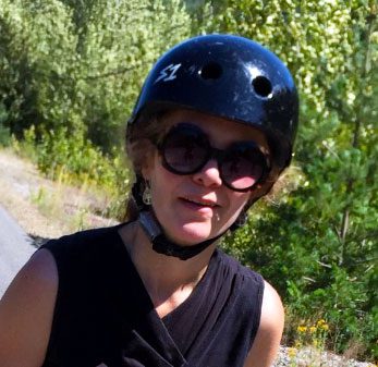 Woman wearing a helmet and sunglasses.