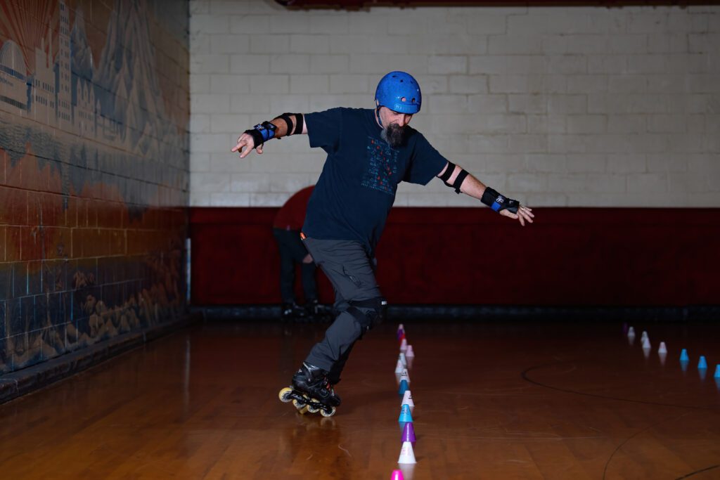 Man in blue helmet roller skating.