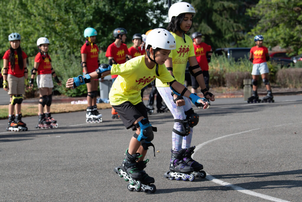 Two young rollerbladers in a group lesson.