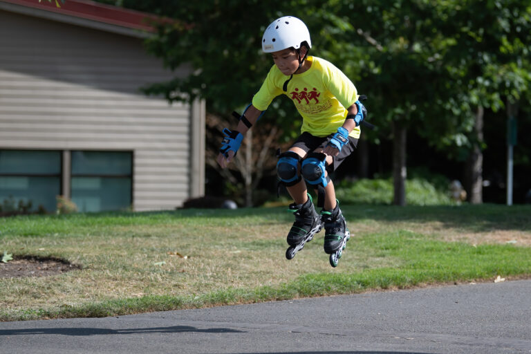 Boy in yellow shirt rollerblading in air.