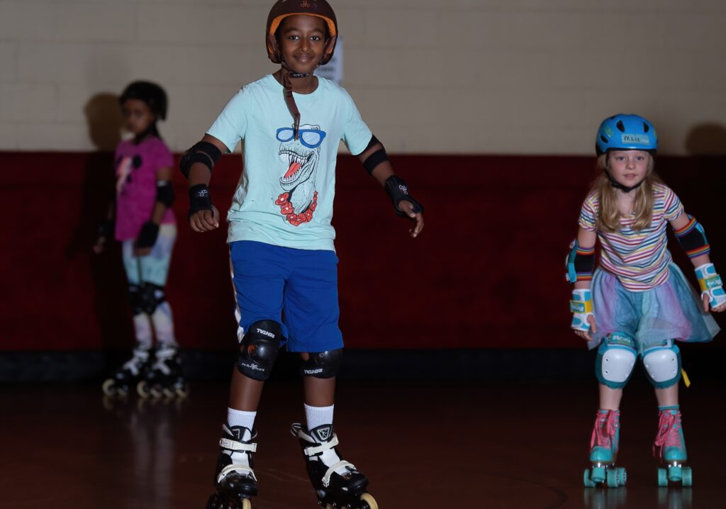 Boy roller skating with dinosaur shirt.