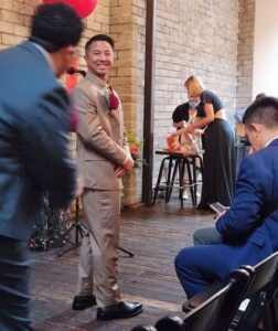 Man in suit smiles at camera during ceremony.