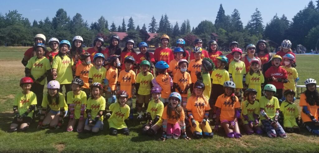 Large group of kids in yellow shirts and helmets.