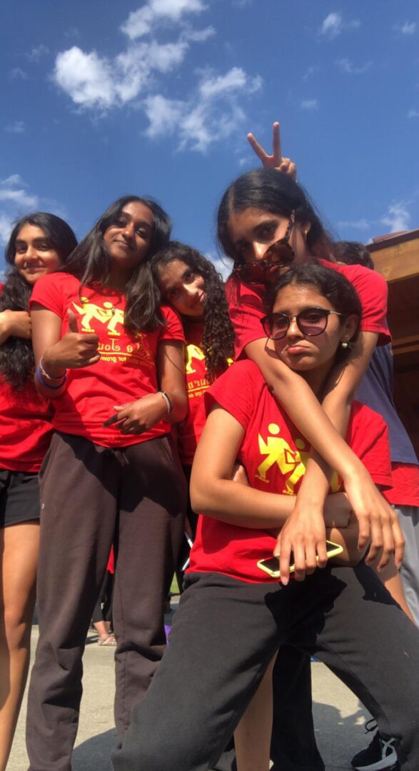 Group of friends wearing red shirts and smiling.