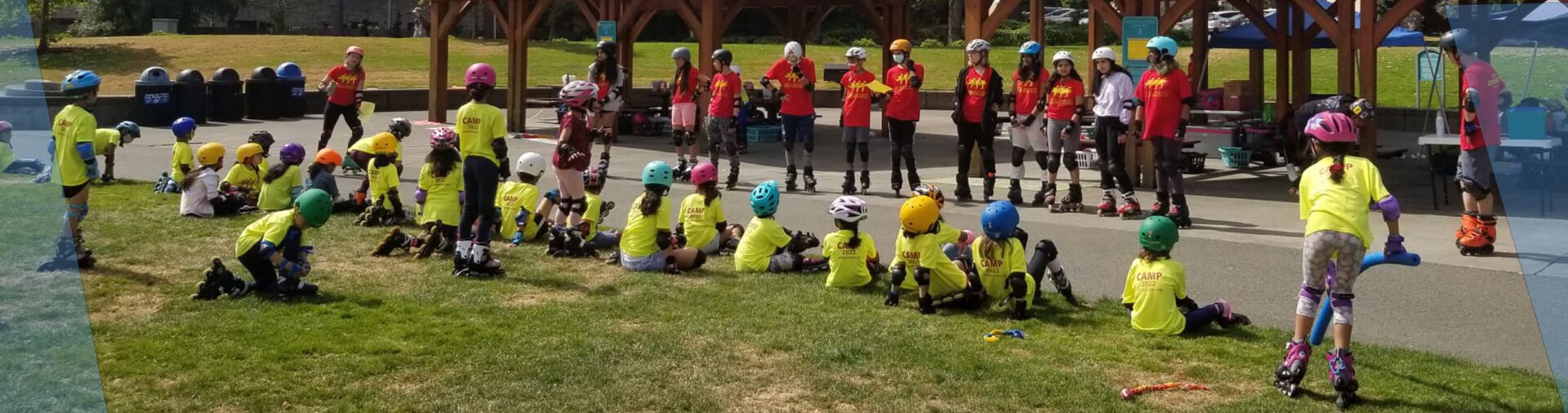 Kids in yellow shirts learning to rollerblade.