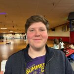 Man in a roller rink smiling at camera.