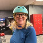 Woman wearing a blue helmet and glasses.