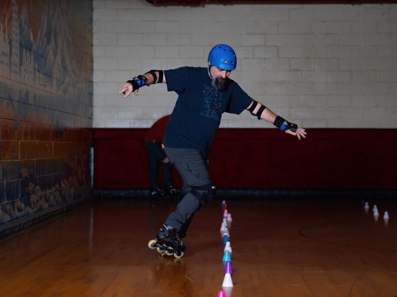 Man in blue helmet roller skating.