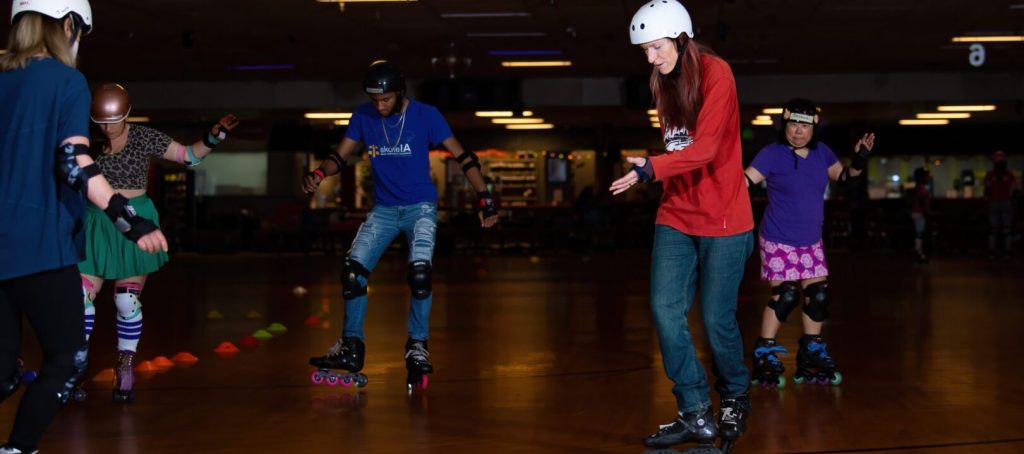 People roller skating at indoor rink.