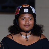 Woman wearing helmet and necklace.