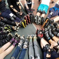 Group of people wearing roller skates.