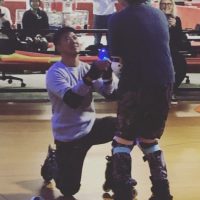 Man proposes to woman on roller skates.