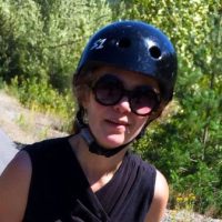 Woman wearing a helmet and sunglasses.